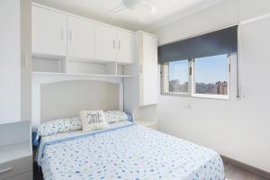 a white bedroom with a bed and two windows at Gandiazar Beach in Playa de Gandia +17 photos