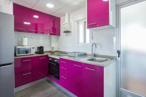 a kitchen with purple cabinets and a sink at Gandiazar Beach in Playa de Gandia