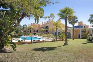 an exterior view of a resort with a swimming pool and palm trees at Apartamento T2 Vilasol Morgadinho in Vilamoura