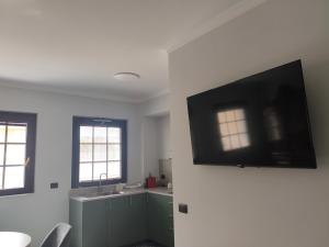 a living room with a flat screen tv on a wall at Strettorooms in Villa San Giovanni