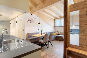 a kitchen and living room with a table and a couch at Living Lerchna - Schöne Aussicht 2 in Maranza