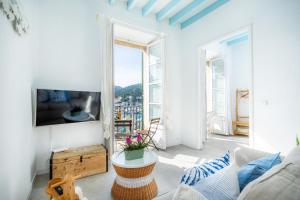 a living room with a couch and a tv at Marina 48 Seafront Apartment in Port de Soller