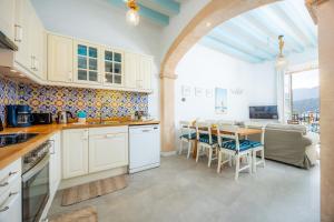 a kitchen and dining room with a table and chairs at Marina 48 Seafront Apartment in Port de Soller