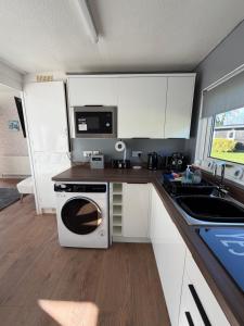 a kitchen with a microwave oven and a stove at Edwards cabin in Caeathro