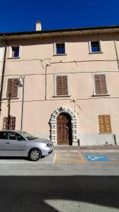 a car parked in front of a building with a door at Appartamento Torricelli in Fossombrone