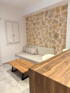 a living room with a couch and a stone wall at Kamara Studios in Alinda