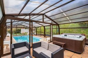a pool house with a hot tub and a patio at La Picarota in Pajares