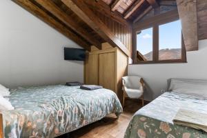 a bedroom with two beds and a window at La Picarota in Pajares +21 photos