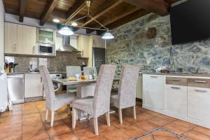 a kitchen with a table and chairs in a room at La Picarota in Pajares