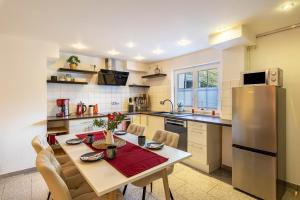 a kitchen with a table and a stainless steel refrigerator at Bergisch Resort Helle in Lindlar