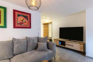 a living room with a couch and a flat screen tv at Bergisch Resort Helle in Lindlar