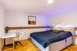 a bedroom with a bed and a desk and a chair at Bergisch Resort Helle in Lindlar