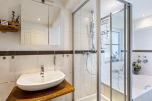 a bathroom with a sink and a shower at Bergisch Resort Helle in Lindlar +26 photos