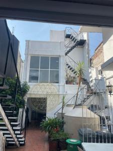 a white house with stairs and a building at Anys Hostal in Mexico City