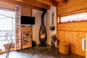 a wood burning stove in a room with a tv at Chalet Les Skieurs in Notre-Dame-du-Pré