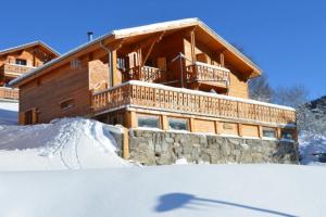 a log cabin in the snow with a shadow at Chalet Les Skieurs in Notre-Dame-du-Pré