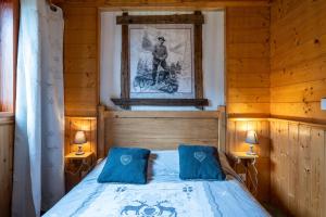 a bedroom with a bed with two blue pillows at Chalet Les Skieurs in Notre-Dame-du-Pré
