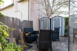 a yard with chairs and a fence and a house at Maison proche de la mer in Arzon