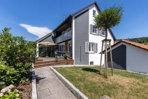 a white house with a patio and a tree at Premium Basislager in Albstadt