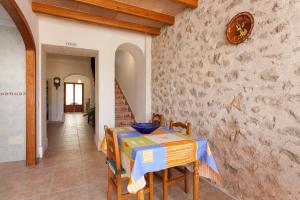 a dining room with a table and a wall at Sa Raval in Maria de la Salut