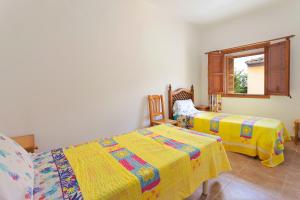 a bedroom with two beds and a window at Sa Raval in Maria de la Salut