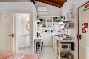 a small kitchen with a desk and a microwave at Quinta do Mestre- Casa Passarinhos in Tavira