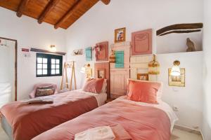 two beds in a room with white walls at Quinta do Mestre- Casa Passarinhos in Tavira