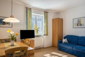 a living room with a blue couch and a table at Valtlhof - Apt 2 in Cornaiano