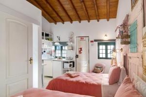 a bedroom with a bed and a kitchen at Quinta do Mestre- Casa Passarinhos in Tavira
