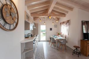 a kitchen and dining room with a large clock on the wall at Casa Bella Vista in Budoni