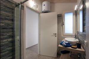 a bathroom with a sink and a glass shower door at Casa Bella Vista in Budoni +22 photos