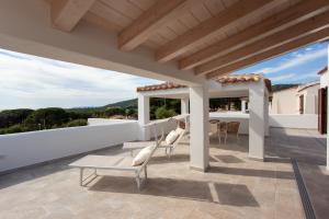 a patio with chairs and a table on a roof at Casa Bella Vista in Budoni