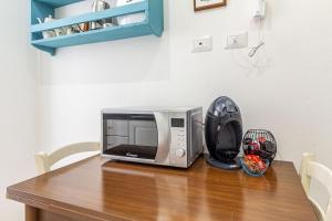 a microwave sitting on top of a wooden table at NURAS - Casa IAIA Alghero city center in Alghero
