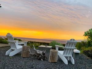 two chairs and a table with a sunset in the background at Casa da Arquinha in Santo Amaro