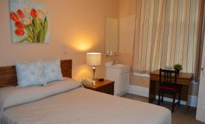 a bedroom with a bed and a desk with a desk at SF Plaza Hotel in San Francisco