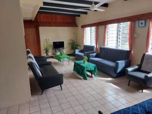 a living room with blue couches and a tv at Newtown Beach Bed and Bath in Nadi