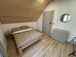 a bedroom with a bed and a wooden ceiling at Samson Park Noclegi in Stacja Dlugi Kat
