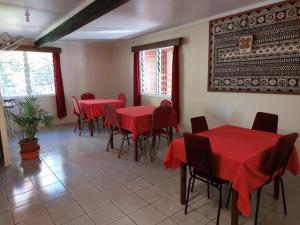 a dining room with red tables and chairs at Newtown Beach Bed and Bath in Nadi