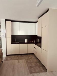 a kitchen with white cabinets and black counter tops at City View Apartment in Mitrovica