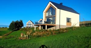 a house on top of a hill with green grass at Dom Skomackie Wzgórze widok na jezioro in Skomack Wielki