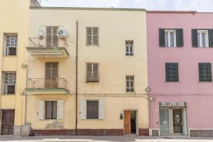 a row of colorful buildings on a street at NURAS - Casa IAIA Alghero city center in Alghero
