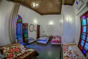 a room with two beds and stained glass windows at Dar Chbili Fès in Fez