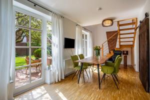 a dining room with a table and green chairs at Altes Fischerhaus II in Cuxhaven