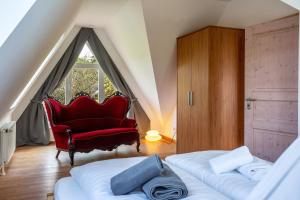a bedroom with a red chair and a bed and a window at Altes Fischerhaus II in Cuxhaven