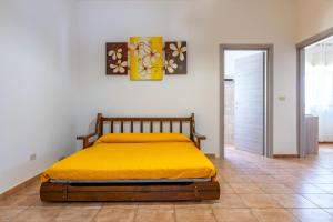 a bedroom with a bed with a yellow blanket at Il Canto della Cicala in San Vito dei Normanni +32 photos