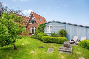 a yard with two chairs and a house at Altes Fischerhaus II in Cuxhaven