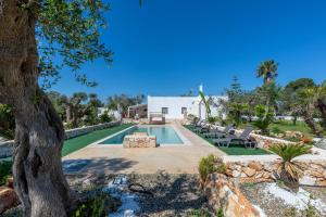 a swimming pool in a yard with a tree at Il Canto della Cicala in San Vito dei Normanni