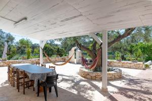a patio with a table and chairs and a hammock at Il Canto della Cicala in San Vito dei Normanni