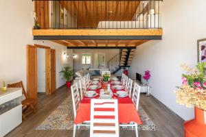 a dining room with a long table with a red table runner at Villa Rodrigues in Boliqueime