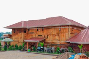 a wooden building with tables and chairs in front of it at Innos Royale Suites in Rukungiri